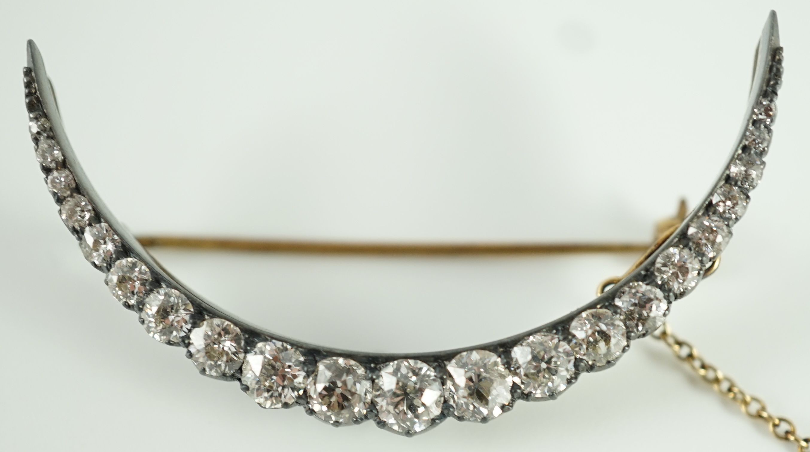 A Victorian, gold, silver and graduated twenty one stone diamond set crescent brooch